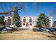 Apartment complex with red roof, beige exterior, manicured landscaping, and ample parking for residents and guests at 7801 W 35Th Ave # 405, Wheat Ridge, CO 80033