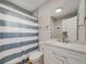 Bathroom with blue and white striped shower curtain and white vanity at 7160 W 24Th Ave, Lakewood, CO 80214