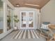Inviting covered entryway with double glass doors, striped rug, and cozy seating area at 7160 W 24Th Ave, Lakewood, CO 80214