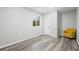 Basement with gray wood floors, white walls, and yellow chair at 26890 E Roxbury Pl, Aurora, CO 80016