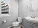 Bathroom featuring a toilet, vanity, round mirror, and window at 26890 E Roxbury Pl, Aurora, CO 80016