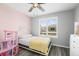 This bedroom features a ceiling fan, natural light, and light pink walls at 26890 E Roxbury Pl, Aurora, CO 80016