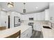 A modern kitchen featuring white cabinets, stainless steel appliances, a large island, and gray plank flooring at 26890 E Roxbury Pl, Aurora, CO 80016
