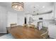 Open concept kitchen with modern lighting, large island, white cabinets, stainless appliances, and light gray wall paint at 26890 E Roxbury Pl, Aurora, CO 80016