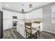 Bright kitchen with white cabinetry, a large island, stainless steel appliances, and light gray walls and plank floors at 26890 E Roxbury Pl, Aurora, CO 80016