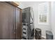 Laundry room featuring stackable washer and dryer, grey wood-look flooring, and storage cabinet at 26890 E Roxbury Pl, Aurora, CO 80016