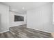 Spacious living room with modern plank flooring, a decorative accent wall, and neutral paint at 26890 E Roxbury Pl, Aurora, CO 80016