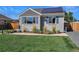 Gray home featuring solar panels, blue shutters, and meticulous landscaping at 771 S Dale Ct, Denver, CO 80219