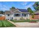 Charming gray home featuring solar panels, blue shutters, and freshly landscaped front yard at 771 S Dale Ct, Denver, CO 80219