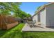 Landscaped backyard featuring a well-manicured lawn, patio table, and planted garden box at 17616 Ponderosa Ave, Parker, CO 80134