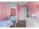 Charming pink bedroom featuring a closet with mirrored doors and light-colored hardwood floors at 17616 Ponderosa Ave, Parker, CO 80134