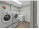 Well-lit laundry room with a front-loading washer, dryer, and deep freezer at 17616 Ponderosa Ave, Parker, CO 80134