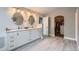 Bright bathroom featuring double sinks, white cabinetry, and natural light from an adjacent open walk-in closet at 7400 S Genoa Cir, Centennial, CO 80016