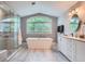 Bright, airy bathroom featuring a modern tub, glass shower, large windows and double vanity at 7400 S Genoa Cir, Centennial, CO 80016