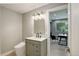 Modern bathroom featuring a stylish vanity, decorative mirror and adjacent open office space with bright, natural light at 7400 S Genoa Cir, Centennial, CO 80016