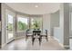 Bright dining area with glass table, four chairs, hardwood floors, and great natural light from bay windows at 7400 S Genoa Cir, Centennial, CO 80016