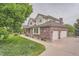 Charming two-story brick home with a three-car garage and manicured lawn at 7400 S Genoa Cir, Centennial, CO 80016