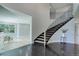 Elegant foyer with a curved staircase, black marble flooring, and contemporary design at 7400 S Genoa Cir, Centennial, CO 80016