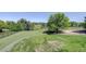 Expansive green space with mature trees, pathways, and a playground nearby at 7400 S Genoa Cir, Centennial, CO 80016