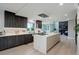 Open kitchen with large island with cooktop, stylish cabinets, stainless steel appliances, and hardwood floors at 7400 S Genoa Cir, Centennial, CO 80016
