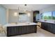 Contemporary kitchen featuring a center island with seating, modern lighting, and stylish cabinetry at 7400 S Genoa Cir, Centennial, CO 80016