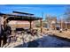 Landscaped backyard featuring a covered patio, seating, and a BBQ grill at 1770 S Yuma St, Denver, CO 80223