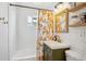 Bathroom featuring stylish vanity and shower/tub with subway tiles and decorative curtain at 1770 S Yuma St, Denver, CO 80223