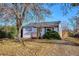 Inviting home exterior featuring a small porch, tidy yard with mature trees and landscaping at 1770 S Yuma St, Denver, CO 80223