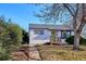 Charming home exterior with a green front door, small porch, and neat landscaping at 1770 S Yuma St, Denver, CO 80223