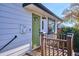 Close-up of a charming home exterior with a green front door and wooden porch at 1770 S Yuma St, Denver, CO 80223