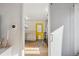 View of kitchen with wood floors, white cabinets, butcher block countertops, and bright yellow door at 1770 S Yuma St, Denver, CO 80223