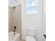 Clean bathroom featuring tiled shower-over-tub, neutral colors, and a bright window at 3340 Backdrop Ct, Castle Rock, CO 80108