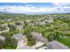Aerial view of a community with stunning mountain views and well-maintained homes nestled among mature trees at 920 Shady Oak Ln, Castle Pines, CO 80108