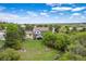 Aerial view of a home with a large lot, mature trees, a well-maintained lawn and a wooden fence at 920 Shady Oak Ln, Castle Pines, CO 80108