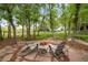 Secluded backyard retreat features a stone patio with Adirondack chairs and lush landscaping at 920 Shady Oak Ln, Castle Pines, CO 80108
