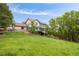 Expansive backyard with a well-maintained lawn, multiple seating areas, and mature trees at 920 Shady Oak Ln, Castle Pines, CO 80108