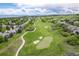 Aerial view of a pristine golf course community with manicured greens, fairways, and beautiful mountain views at 920 Shady Oak Ln, Castle Pines, CO 80108