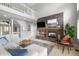 An airy living room with stone fireplace, balcony, neutral colors and lots of natural light at 920 Shady Oak Ln, Castle Pines, CO 80108