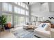 Bright and airy living room featuring floor-to-ceiling windows, a neutral color palette, and a modern sectional at 920 Shady Oak Ln, Castle Pines, CO 80108