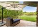 Charming patio area with comfortable seating, an umbrella, and a view of the expansive backyard at 920 Shady Oak Ln, Castle Pines, CO 80108