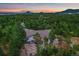 Aerial view of a home nestled in a forest with distant mountain views at sunset at 8045 Eagle Rd, Larkspur, CO 80118