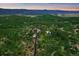 Aerial view of a home with a long driveway surrounded by lush greenery and mountain views at 8045 Eagle Rd, Larkspur, CO 80118