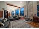 Cozy living room featuring hardwood floors, a stone fireplace, and oversized windows at 8045 Eagle Rd, Larkspur, CO 80118