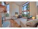 Bright living room with stone fireplace, hardwood floors, and large picture windows showcasing mountain views at 8045 Eagle Rd, Larkspur, CO 80118