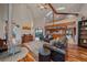 Bright, open-concept living room featuring hardwood floors and a stone fireplace at 8045 Eagle Rd, Larkspur, CO 80118