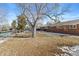 Large backyard with mature trees and partial snow cover at 3433 E Costilla Ave, Centennial, CO 80122