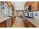 Kitchen with wood cabinets, stainless steel appliances, and hardwood floors at 3433 E Costilla Ave, Centennial, CO 80122