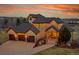 Elegant home featuring a three-car garage and stone archway at the entrance at 4337 W Hinsdale Ave, Littleton, CO 80128