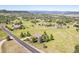 An aerial view of a neighborhood with homes interspersed among green fields and winding roads at 3441 Medallion Rd, Castle Rock, CO 80104