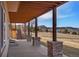 Covered porch with stone columns, wood ceiling, and scenic views of the surrounding landscape at 3441 Medallion Rd, Castle Rock, CO 80104